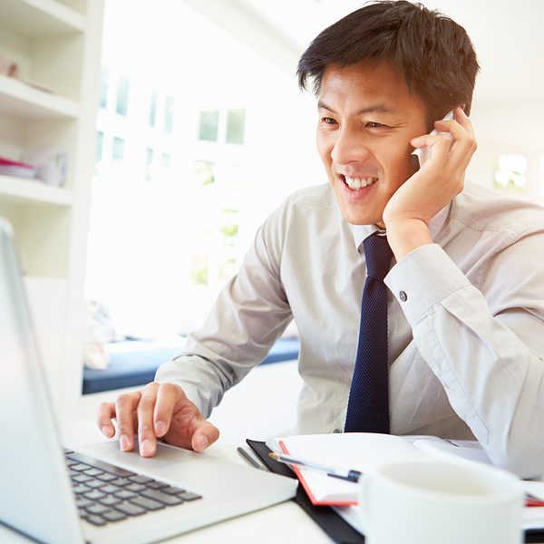 Asian Businessman Working From Home Using Mobile Phone